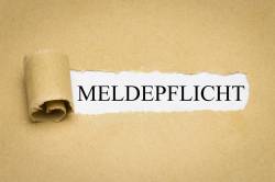 Foto: Aufgerissenes Papier mit Aufschrift Meldepflicht